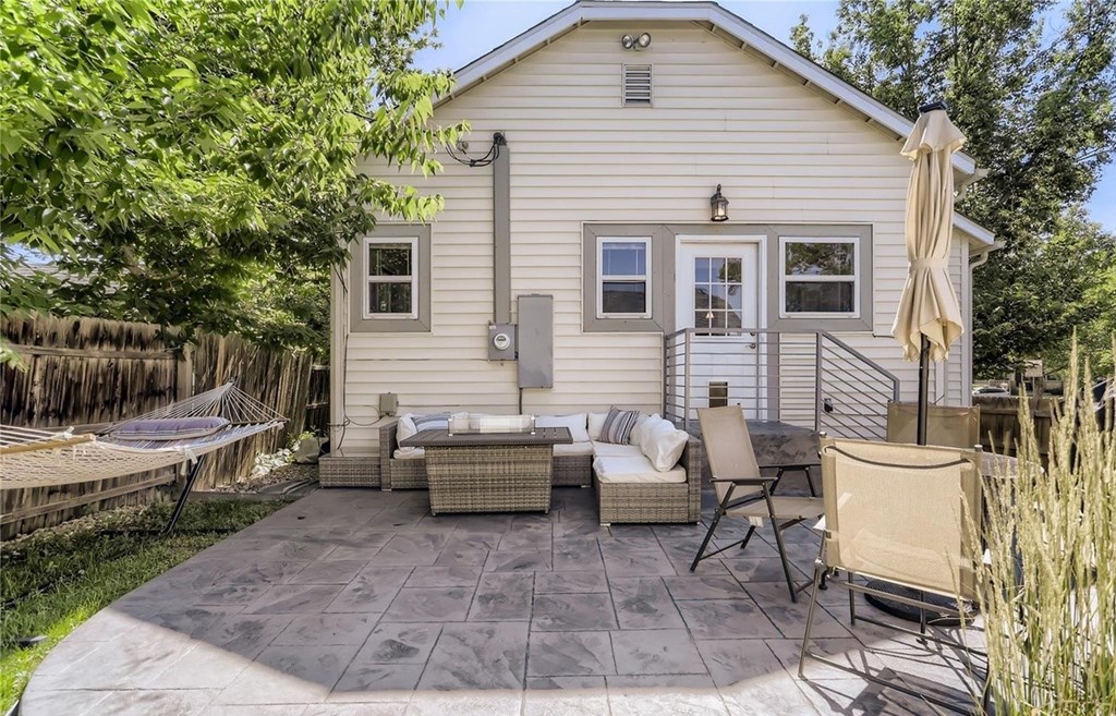 a backyard with a house and a patio with furniture