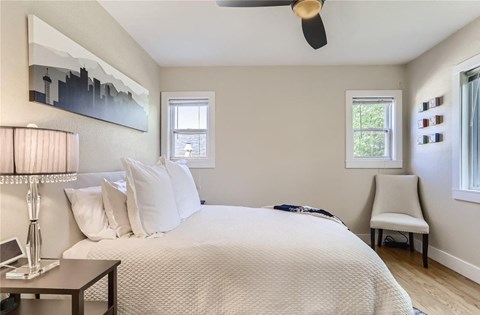 a bedroom with a bed and a chair and a ceiling fan