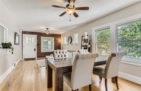a dining room with a table and chairs and a ceiling fan