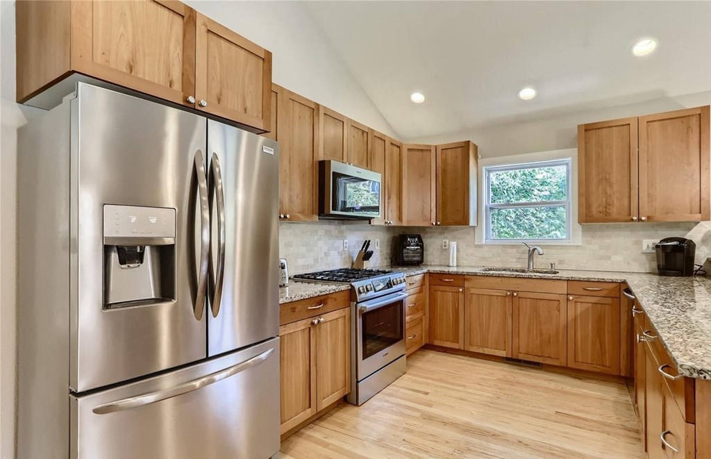 a kitchen with stainless steel appliances and wooden cabinets
