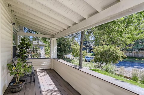 a porch with a view of a pool and trees