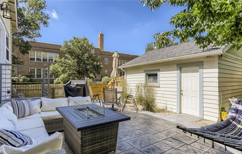 the backyard has a patio with a fire pit and a shed