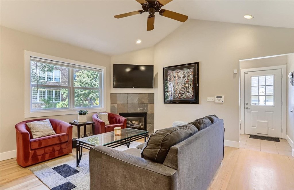 a living room with a couch and a chair and a ceiling fan