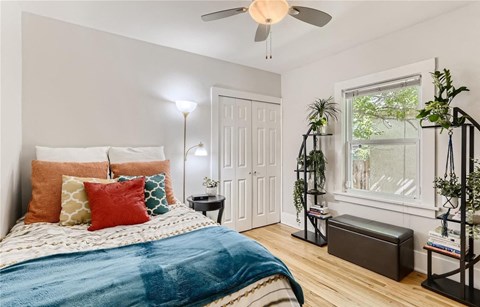 a bedroom with a bed and a ceiling fan