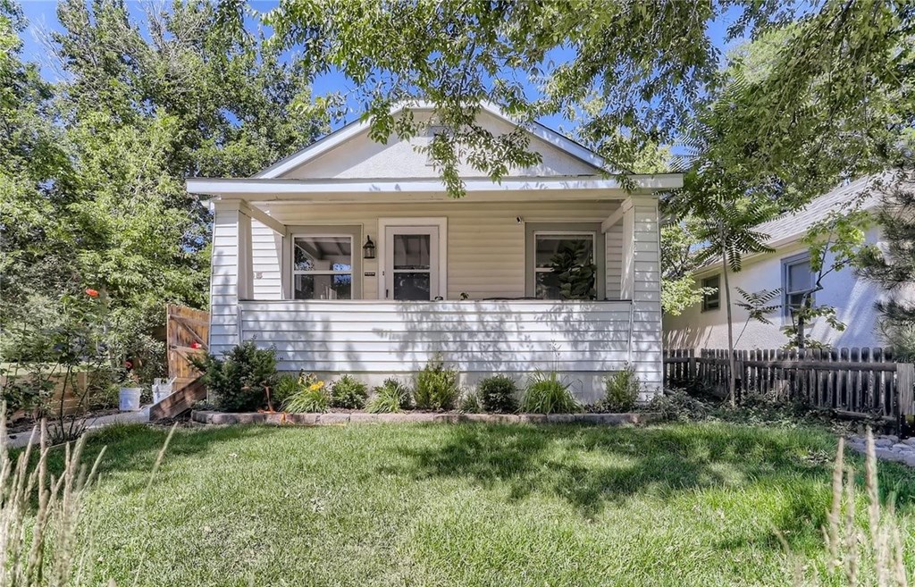 a small white house with a yard in front of it