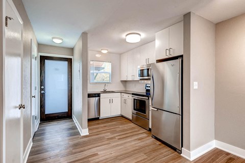 a renovated kitchen with stainless steel appliances and white cabinets
