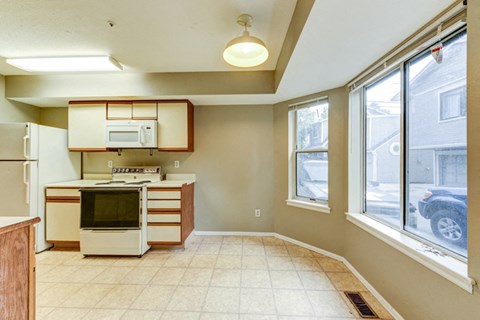 A kitchen with a white refrigerator, microwave, and oven.