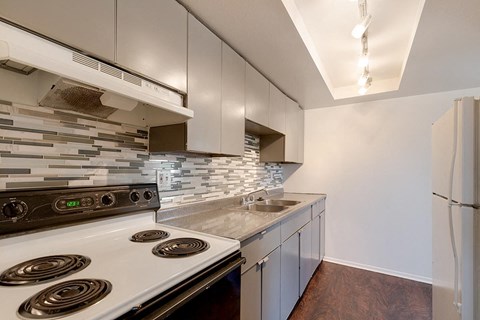 A kitchen with a stove top oven and a refrigerator.
