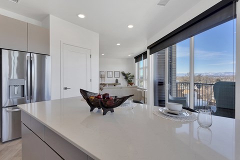 a kitchen with a large island and a bowl of fruit on the counter