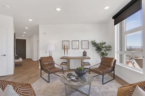 a living room with chairs and a table and a large window