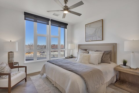 a bedroom with a large bed and a ceiling fan