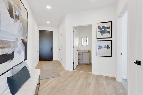 a living room with a couch and a hallway to a bathroom