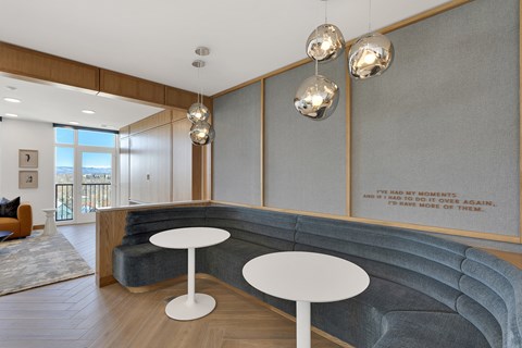 a lobby with a blue couch and two white tables