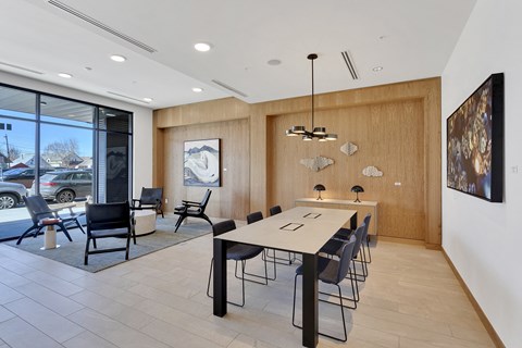 a dining room with a long table and chairs and a large window