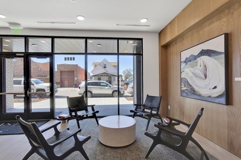 a lobby with chairs and a table and a painting on the wall