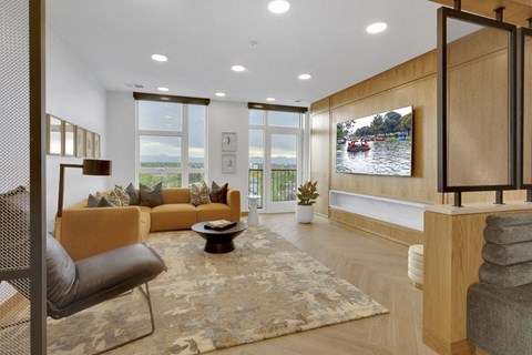 the living room has a large screen tv on the wall