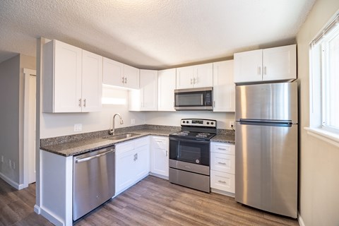 A kitchen with white cabinets and stainless steel appliances.