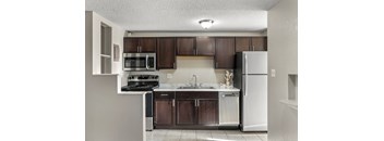 A kitchen with brown cabinets and a white refrigerator.
