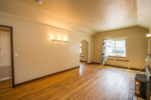 A living room with wood floors and a fireplace.