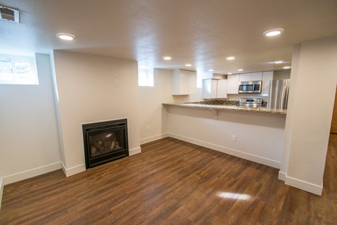 A living room with a fireplace and wooden floors.