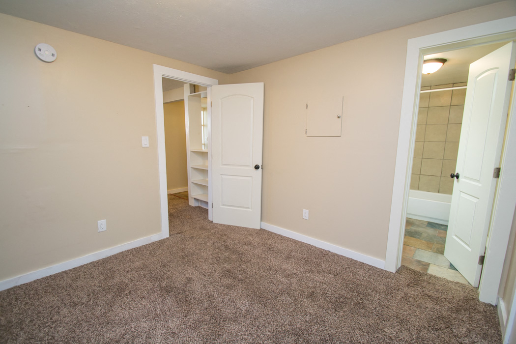 a bedroom with a closet and a door to a bathroom