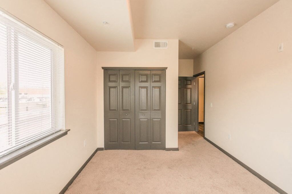 an empty room with a large window and a door