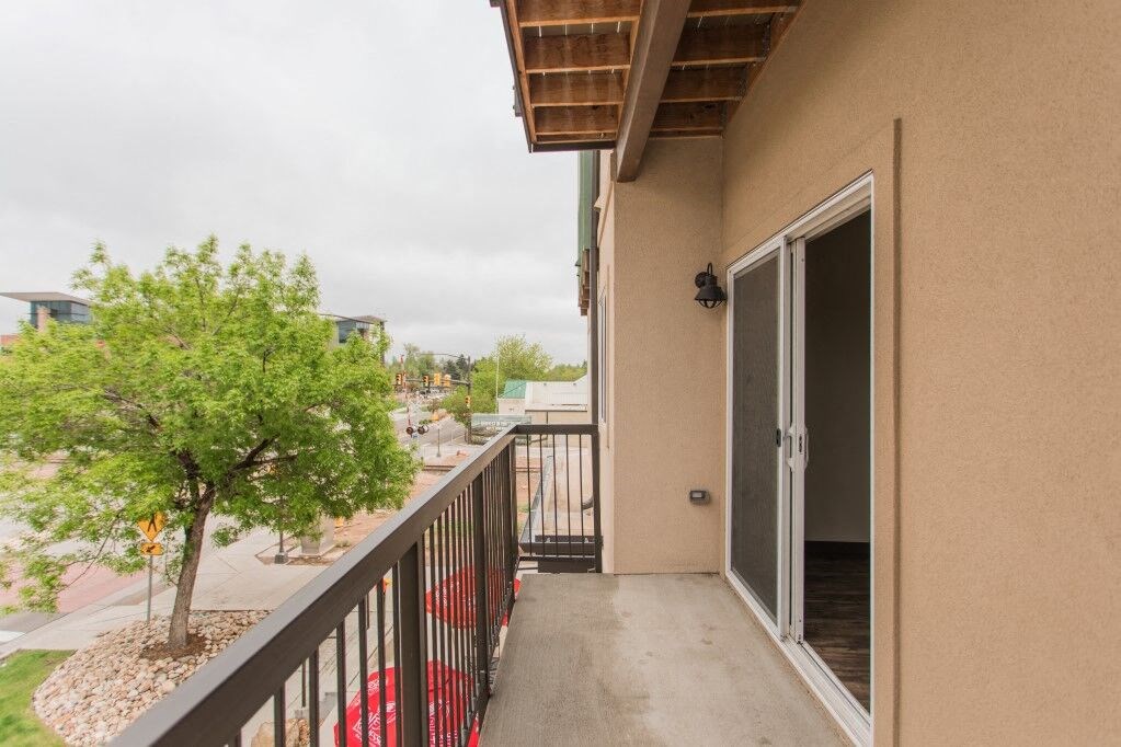 a balcony with a tree and a door to a building
