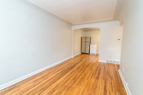 a spacious living room with wood floors and white walls