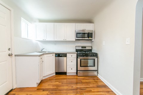 a kitchen with white cabinets and stainless steel appliances