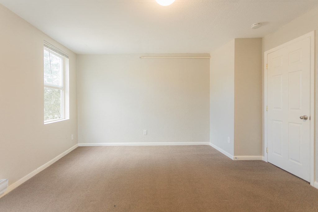 A room with a carpeted floor and a white door.
