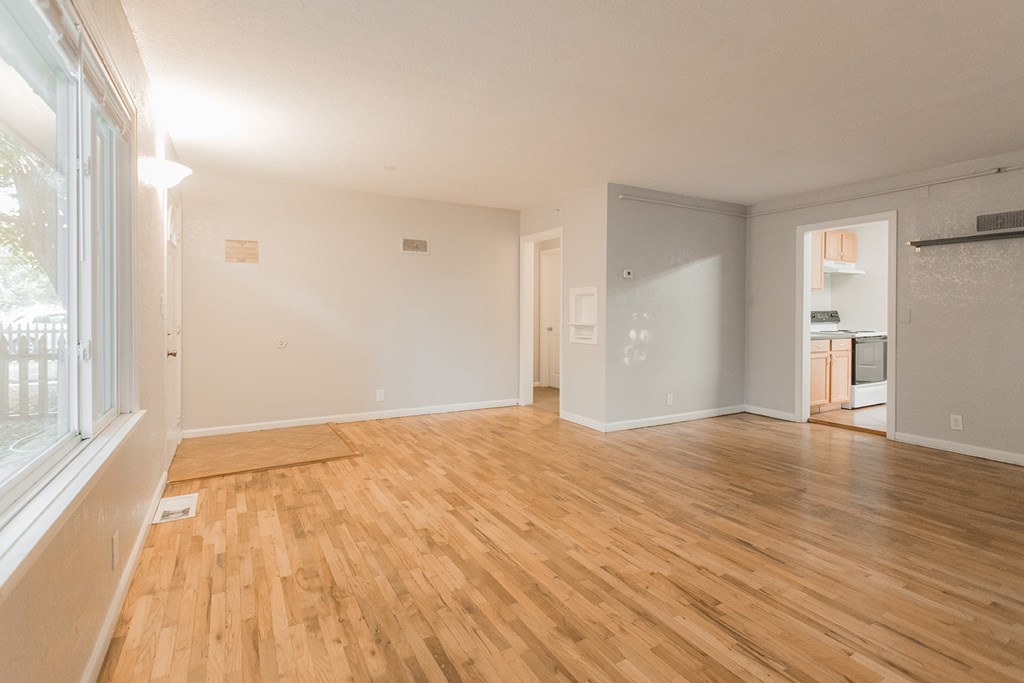 A room with wooden flooring and white walls.