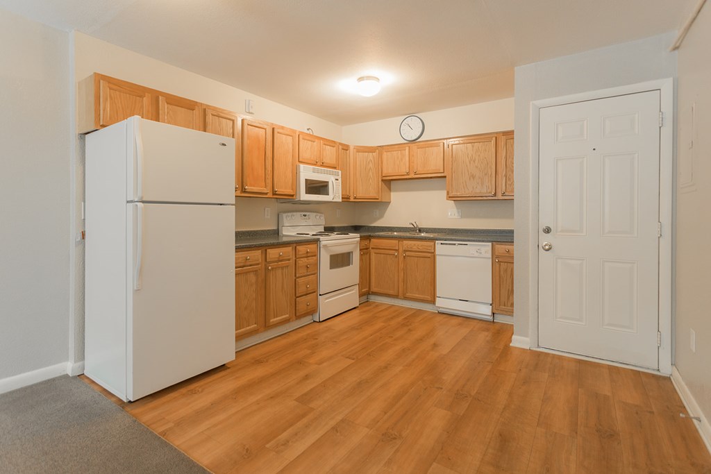A kitchen with wooden cabinets and a white refrigerator.
