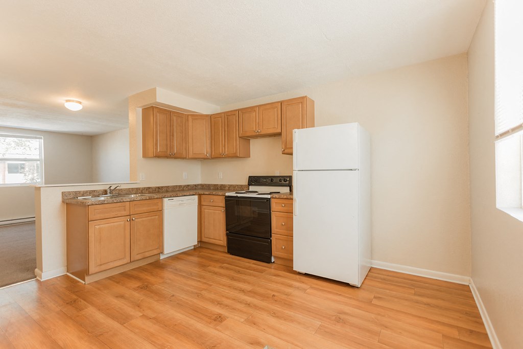 A kitchen with wooden cabinets and a white refrigerator.