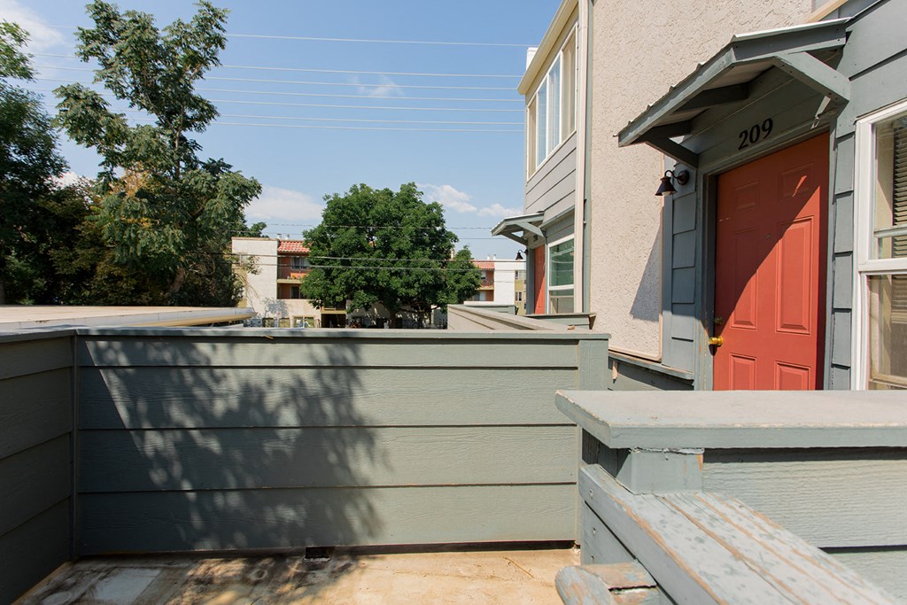 A house with a red door and a grey wall.