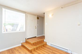 A room with a white door and wooden steps.