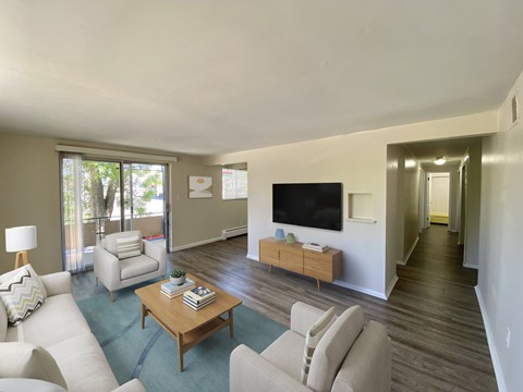 A living room with a white couch, a wooden coffee table, and a flat screen TV.