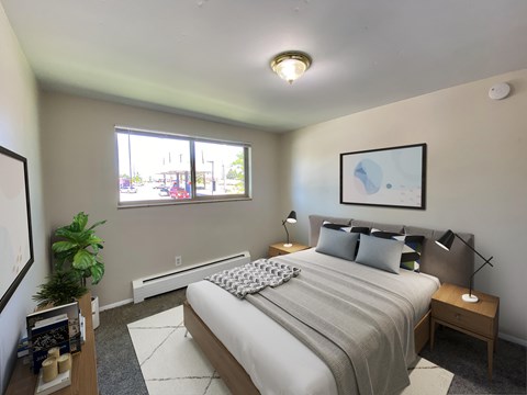 A bedroom with a large bed and a window overlooking a street.