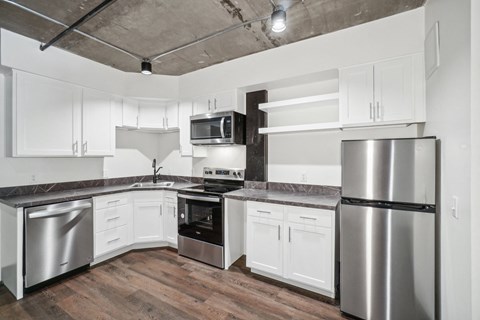 a kitchen with stainless steel appliances and white cabinets