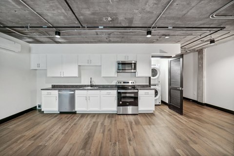 an empty kitchen with white cabinets and stainless steel appliances