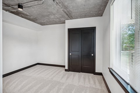 an empty room with a door and a large window