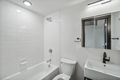 a white bathroom with a toilet sink and tub