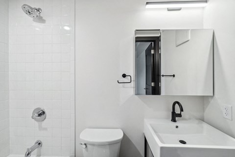 a white bathroom with a sink toilet and a mirror
