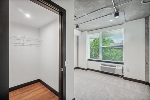 an empty room with a large window and white walls