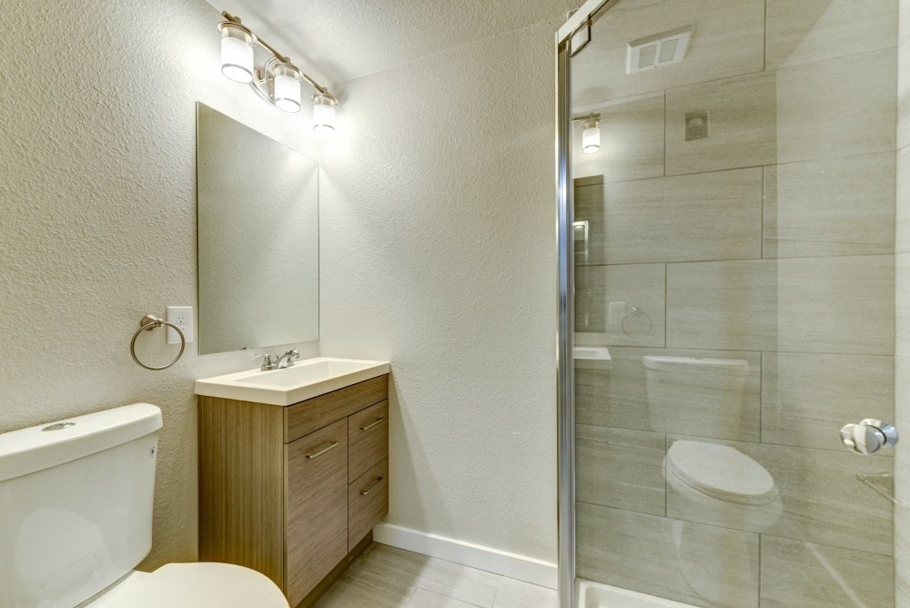 a bathroom with a shower and a toilet and a sink