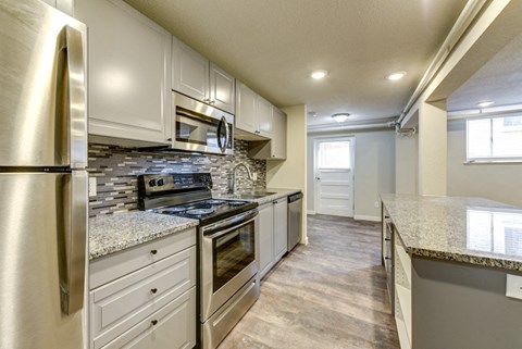 a kitchen with white cabinets and stainless steel appliances and granite counter tops