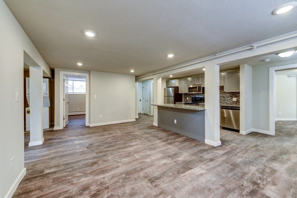 the living room and kitchen of a new home with a hard wood floor