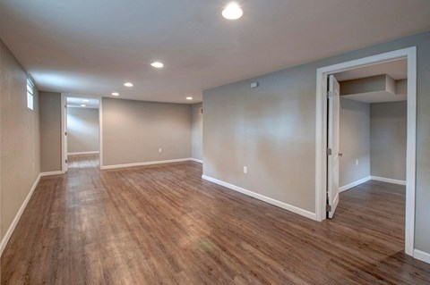 a renovated living room with a hard wood floor and grey walls