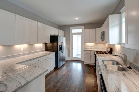 a kitchen with marble counter tops and white cabinets