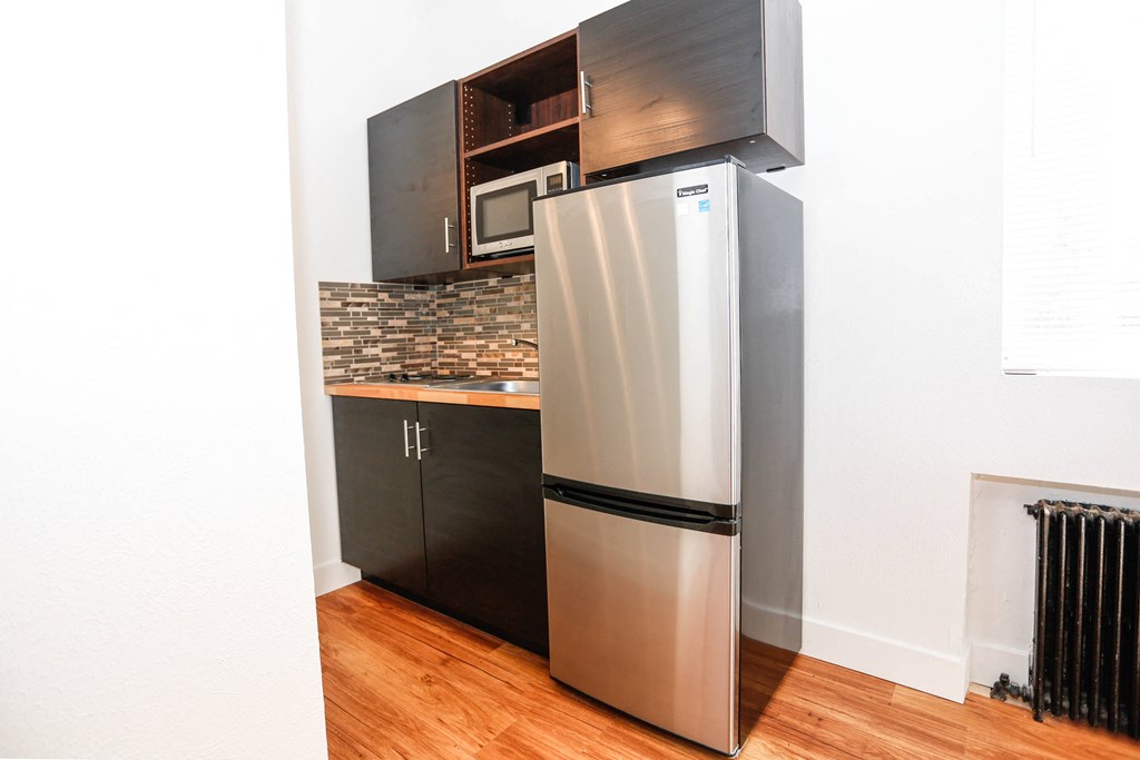 a kitchen with a stainless steel refrigerator and black cabinets