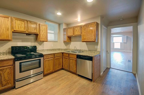 an empty kitchen with wooden cabinets and stainless steel appliances